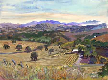 This mountain valley with oak trees and coastal mountains surrounding it is has a grain field that has be freshly mowed and the rows are promandant with various shades of yellows and greens.