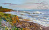 The ocean in Cambria hitting the shore with vibrant colors in the rocky shore and sea.
