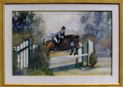 A red horse with a rider is jumping a white fence in a jumping course.
